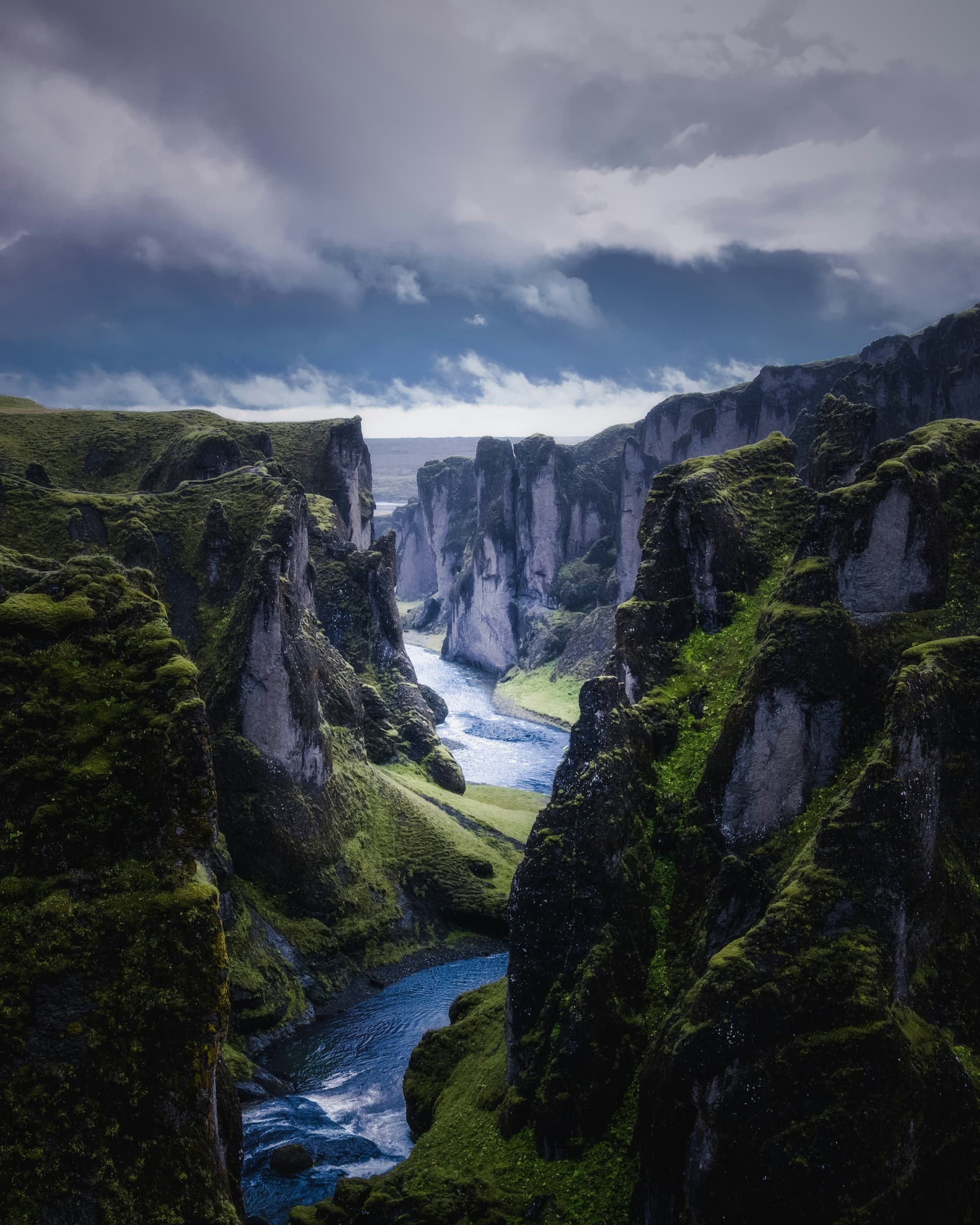 A river winding through a deep, moss-covered canyon